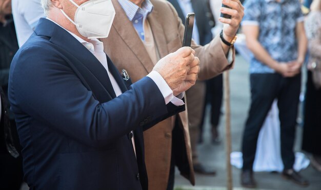 Zdjęcie mężczyzna trzyma telefon z maską medyczną