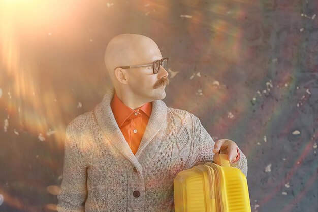 mężczyzna trzyma walizkę, koncepcja turystyczna, wycieczka wąsaty facet w okularach, ekscentryczny typ