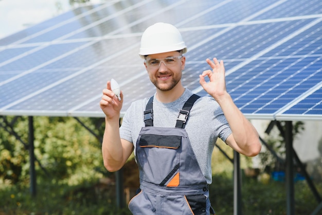 Mężczyzna trzyma żarówkę w swojej koncepcji energetycznej, słońce jest czyste po pracy i zastępuje energię, która wytwarza dwutlenek węgla.