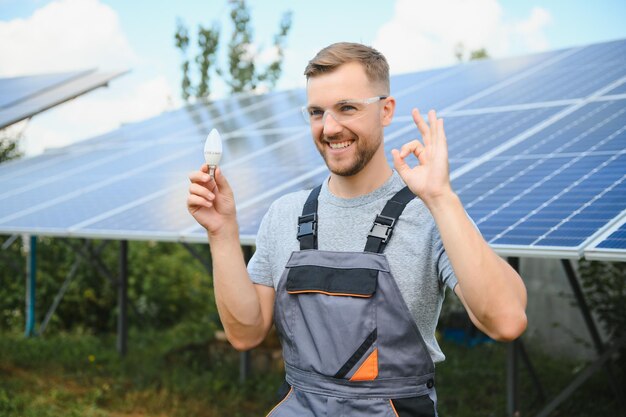 Mężczyzna trzyma żarówkę w swojej koncepcji energetycznej, słońce jest czyste po pracy i zastępuje energię, która wytwarza dwutlenek węgla.