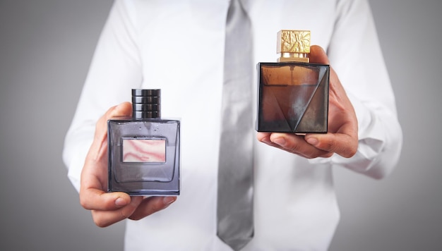 Mężczyzna trzymający butelki perfum