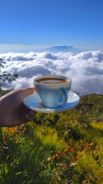 Zdjęcie mężczyzna trzymający filiżankę kawy na tle nieba