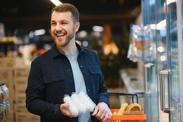 Mężczyzna trzymający pudełko na jajka w pudełku na jajka w supermarkecie Kup kartonowy mężczyzna trzyma sprawdzanie koncepcji konsumenta