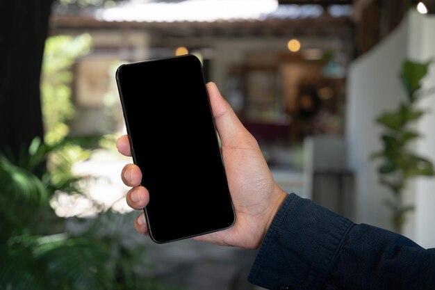 Mężczyzna trzymający smartfon z pustym ekranem zbliżenie rąk Miejsce na tekst