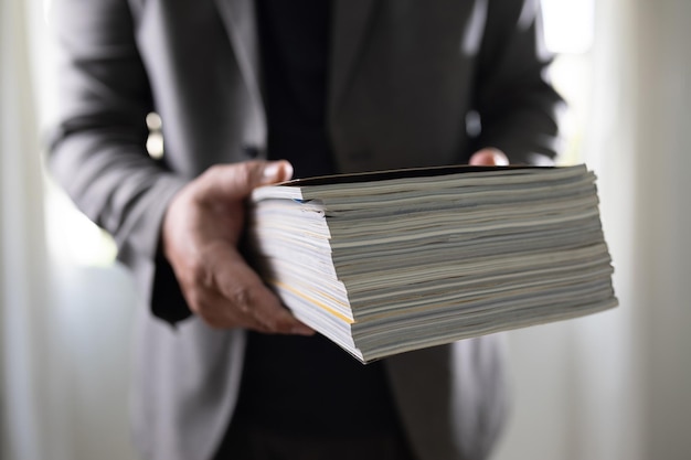 Mężczyzna trzymający stos mediów na stronie publikacji magazynu, aby ułożyć dane z badań komunikacji, aby nauczyć się reklam i obiektów kosmicznych banerów