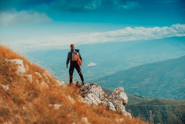 mężczyzna turysta osiągający cel życiowy na szczycie góry Sport przygodowy na świeżym powietrzu
