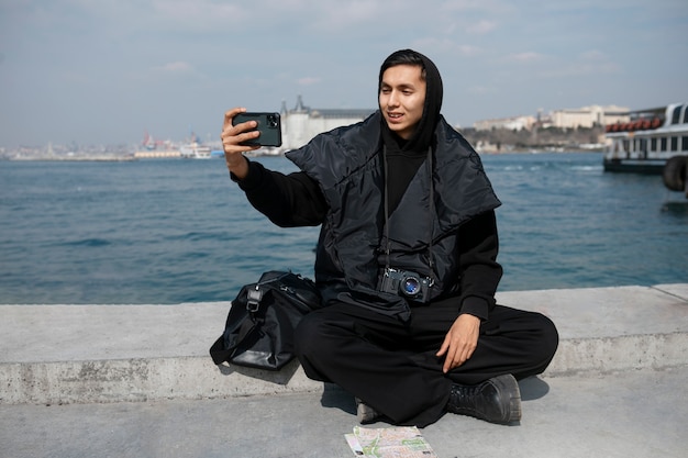 Mężczyzna turysta robi selfie ze smartfonem podczas podróży