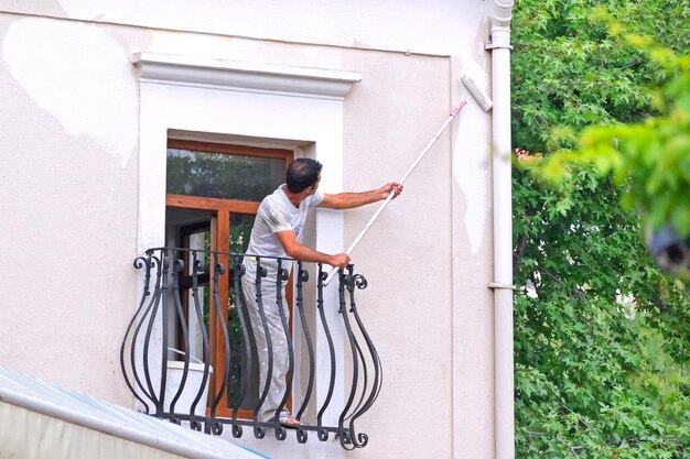 Mężczyzna tynkarze ściana z otwartym balkonem