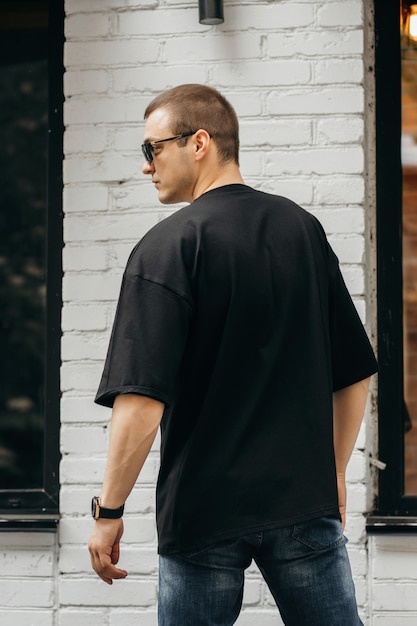 Mężczyzna Ubrany W Czarną Pustą Koszulkę Z Miejscem Na Logo Lub Projekt Mock Up