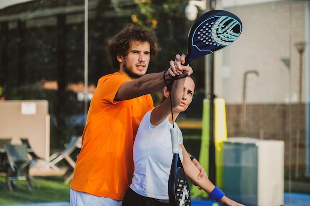Zdjęcie mężczyzna uczący kobiety tenisa