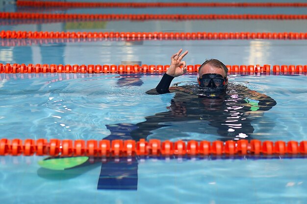 Zdjęcie mężczyzna uczy nurkowania w basenie, trener pływania