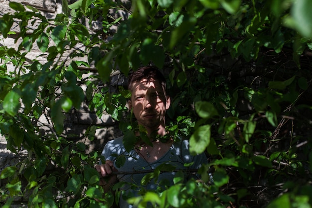 Mężczyzna ukryty w zielonych krzewach