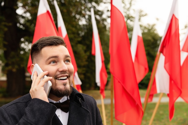 Mężczyzna używa smartphone z flaga Polska behind