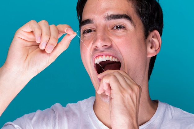 Mężczyzna używa zęby nici dentystycznej portret