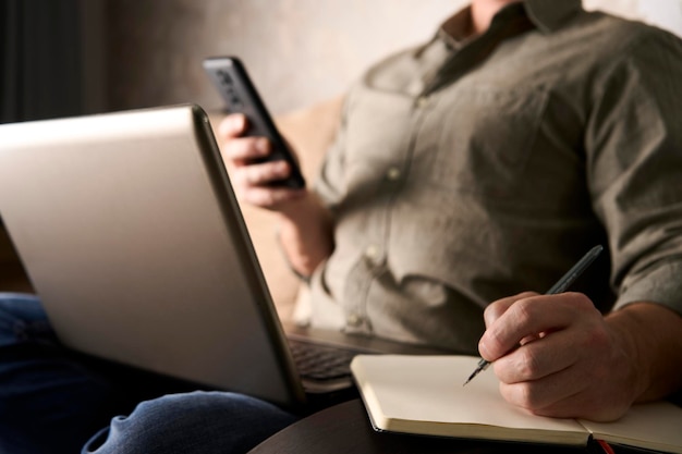 Mężczyzna używający notebooka i pracujący na laptopie