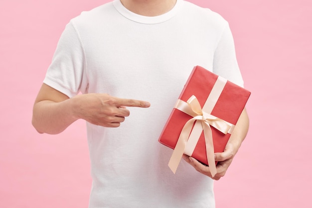 Mężczyzna w białej koszulce trzymający w rękach pudełka na prezenty
