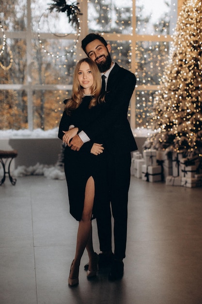 Mężczyzna w czarnym garniturze i kobieta w czarnej sukience świętują Nowy Rok