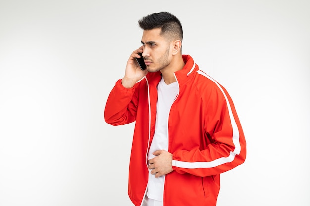 Mężczyzna w czerwonym stroju sportowym rozmawia przez telefon z głośnikiem.