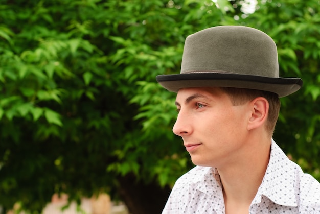 Zdjęcie mężczyzna w filcowym kapeluszu na zewnątrz, bliska twarz, portret profil
