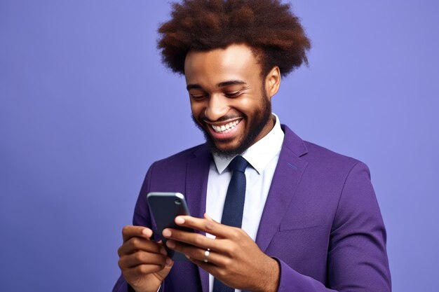Mężczyzna w fioletowym garniturze uśmiecha się, patrząc na swój smartfon.