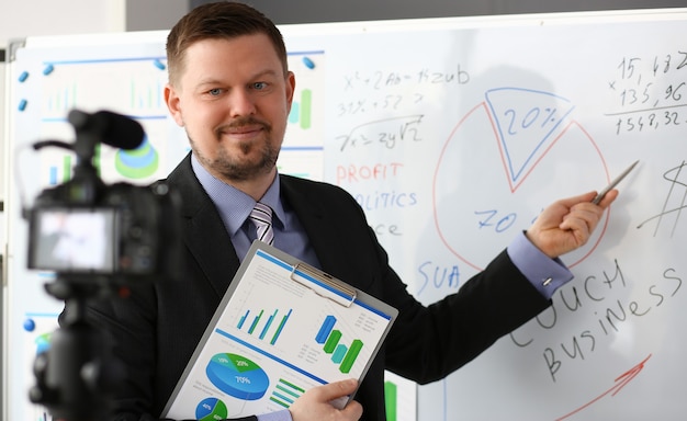 Zdjęcie mężczyzna w garniturze i pod krawatem pokazuje wykresy statystyk