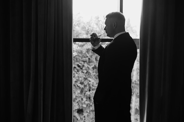 Mężczyzna w garniturze stoi przed oknem z zasłoną, na której jest napisane "nie"