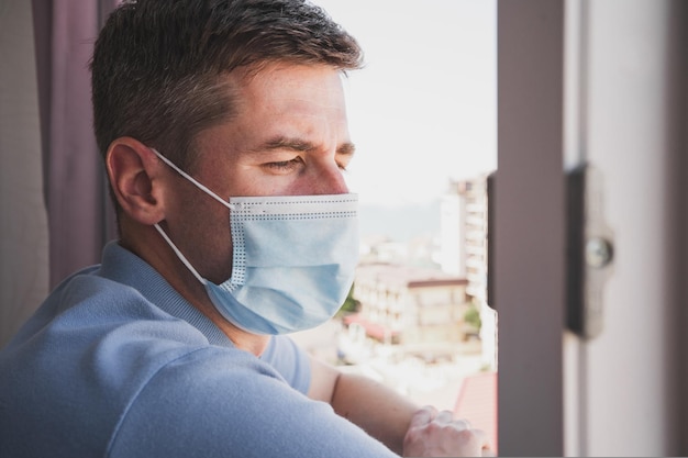 Zdjęcie mężczyzna w izolacji z przeziębieniem mężczyzna z maską medyczną zbliżenie twarzy zamaskowanego mężczyzny