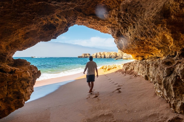 Mężczyzna w jaskini na plaży w Praia da Coelha Algarve Albufeira Portugalia