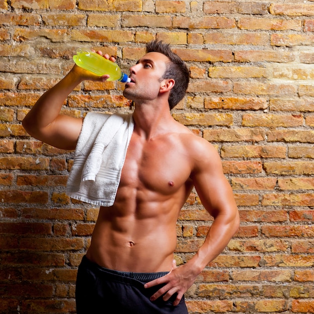 mężczyzna w kształcie mięśni na siłowni zrelaksowany picie
