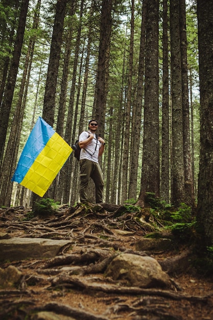 Mężczyzna w lesie z ukraińską flagą