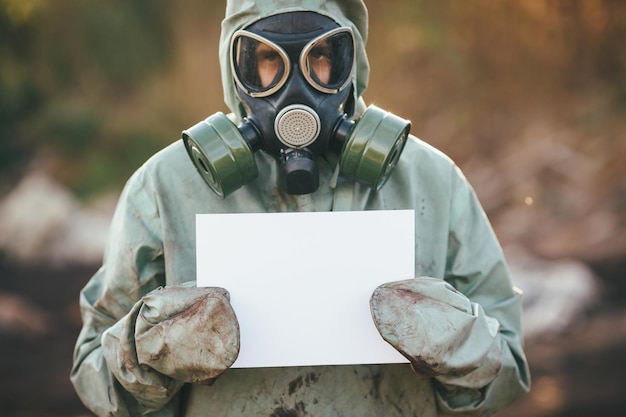 Zdjęcie mężczyzna w masce gazowej i zielonym wojskowym ubraniu, pokazujący papier w schowku