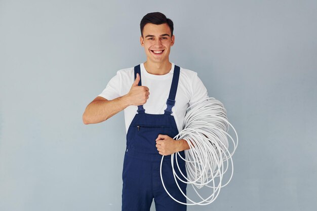 Mężczyzna w niebieskim mundurze stoi w studiu na białym tle