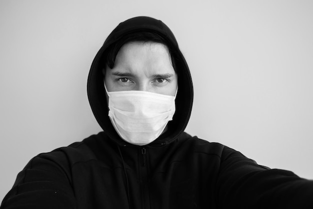 Mężczyzna w ochronnej masce na twarz pracownik biurowy w białej koszuli ubrany w maskę chroniącą przed covid19 Portret biznesmena w czasie pandemii