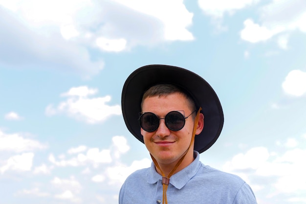 Mężczyzna w okularach przeciwsłonecznych portret rolnika z niebieskim niebem w tle młody mężczyzna w okularach przeciwsłonecznych