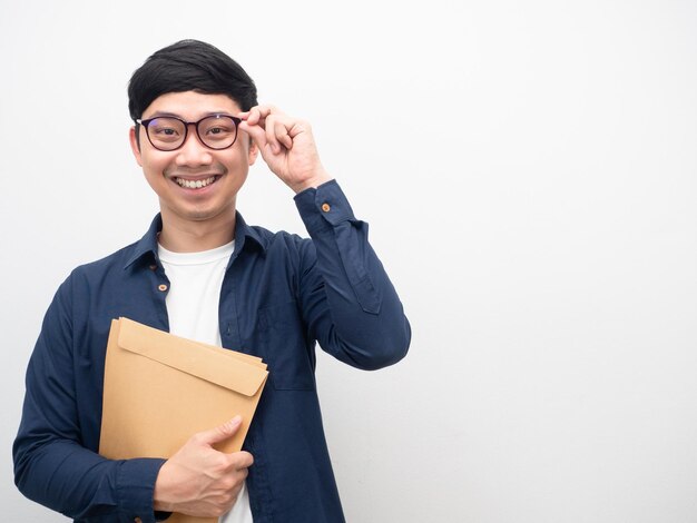 Mężczyzna w okularach trzymający kopertę z dokumentem szczęśliwy uśmiech białe tło