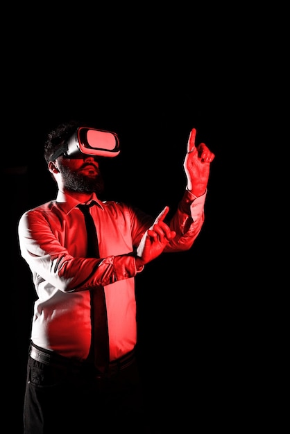 Mężczyzna w okularach VR i wskazujący ważne wiadomości jednym palcem i długopisem Biznesmen mający okulary wirtualnej rzeczywistości i pokazujący kluczowe informacje