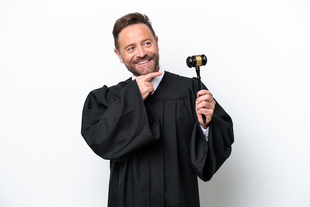 Mężczyzna w średnim wieku sędzia na białym tle patrząc w bok i uśmiechnięty