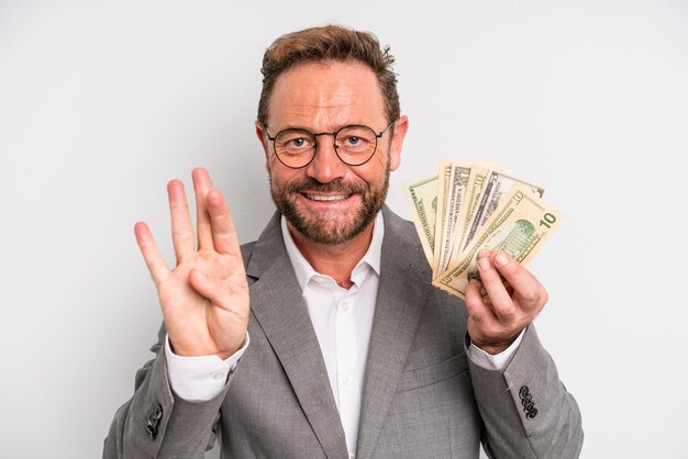 Mężczyzna w średnim wieku uśmiecha się i wygląda przyjaźnie pokazując koncepcję banknotów dolarowych numer cztery