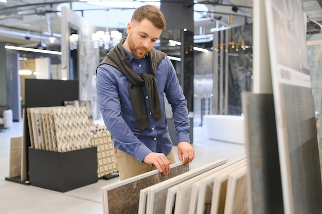 Zdjęcie mężczyzna w średnim wieku wybierający ceramiczne płytki i naczynia do domowej łazienki