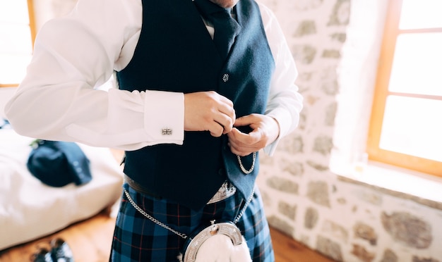 Mężczyzna W Szkockiej Narodowej Sukience Zapina Kamizelkę I Przygotowuje Się Do Ceremonii ślubnej
