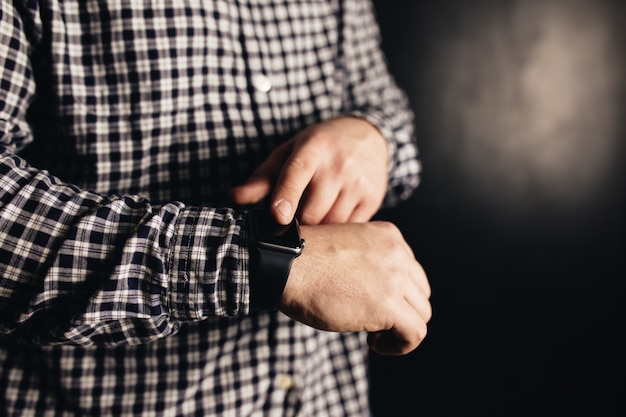 Zdjęcie mężczyzna w zwykłym ubraniu klika zegarki ręczne, bransoletka, czarne rozmyte tło