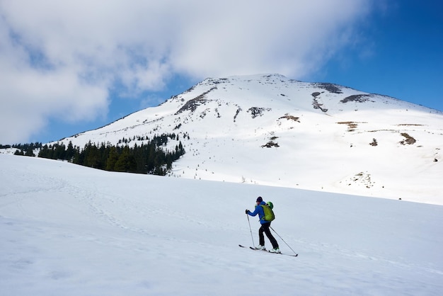 Mężczyzna wspinający się podczas skitouringu w spektakularnie białych górach