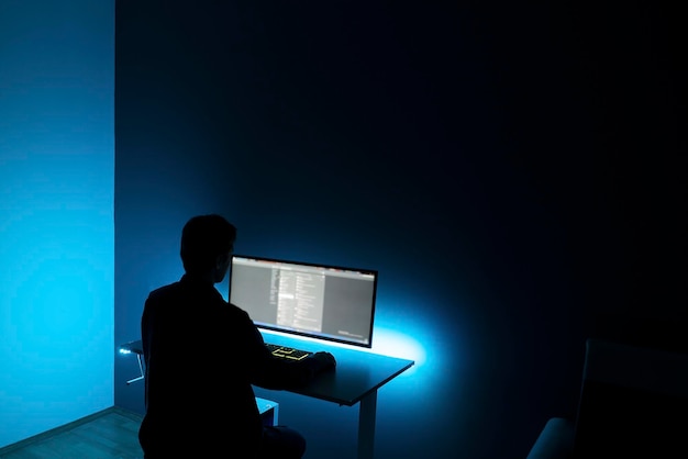 Mężczyzna wykonujący pracę na komputerze późno w nocy w domu