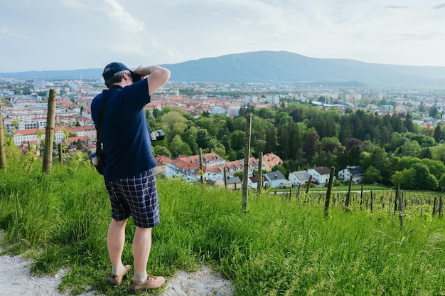 Mężczyzna z aparatem fotografujący winnicę w Mariborze w Słowenii