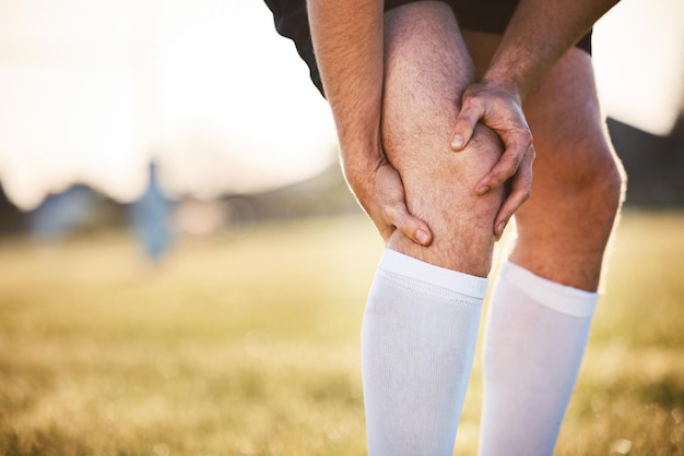 Mężczyzna z bólem kolana z kontuzją i wypadkiem podczas ćwiczeń na świeżym powietrzu ze skurczami i napięciem mięśni Sport fitness i osoba płci męskiej z rękami na nogach kryzys zdrowotny i gracz rugby z zapaleniem