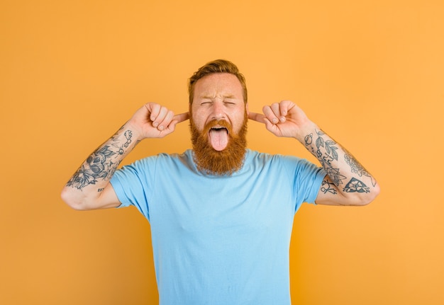 Zdjęcie mężczyzna z brodą i tatuażem wystawia język