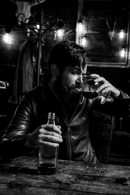 Mężczyzna z brodą trzyma szklankę brandy Macho pije Degustację Degustację Przystojny brodaty mężczyzna Nie prowadź po alkoholu