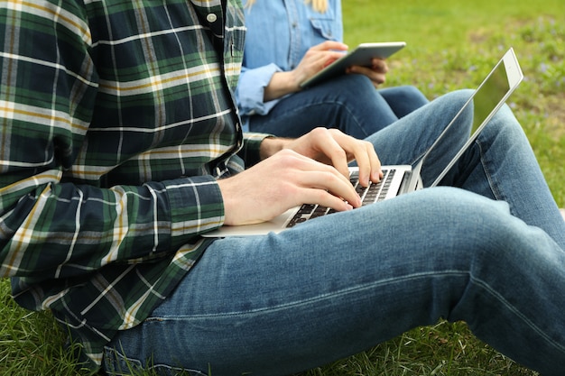 Mężczyzna Z Laptopem I Kobieta Z Tabletem Pracują W Parku. Praca Na Zewnątrz