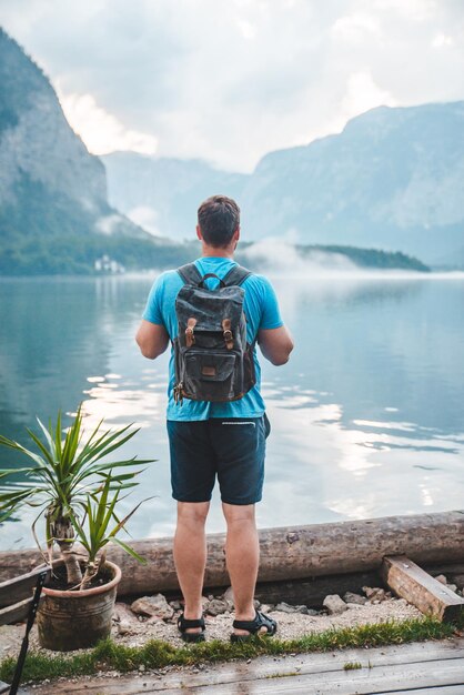 Mężczyzna z plecakiem patrzący na morze w Hallstatt