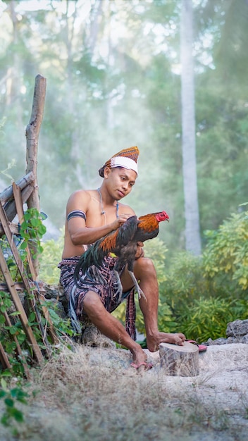 Mężczyzna z plemienia Sabu-Raijua trzymający koguta